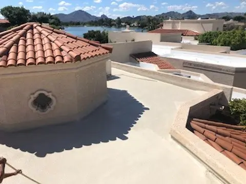 Coated flat foam roof with clay tile accents on a lakeside home in Scottsdale, by Leal Roofing