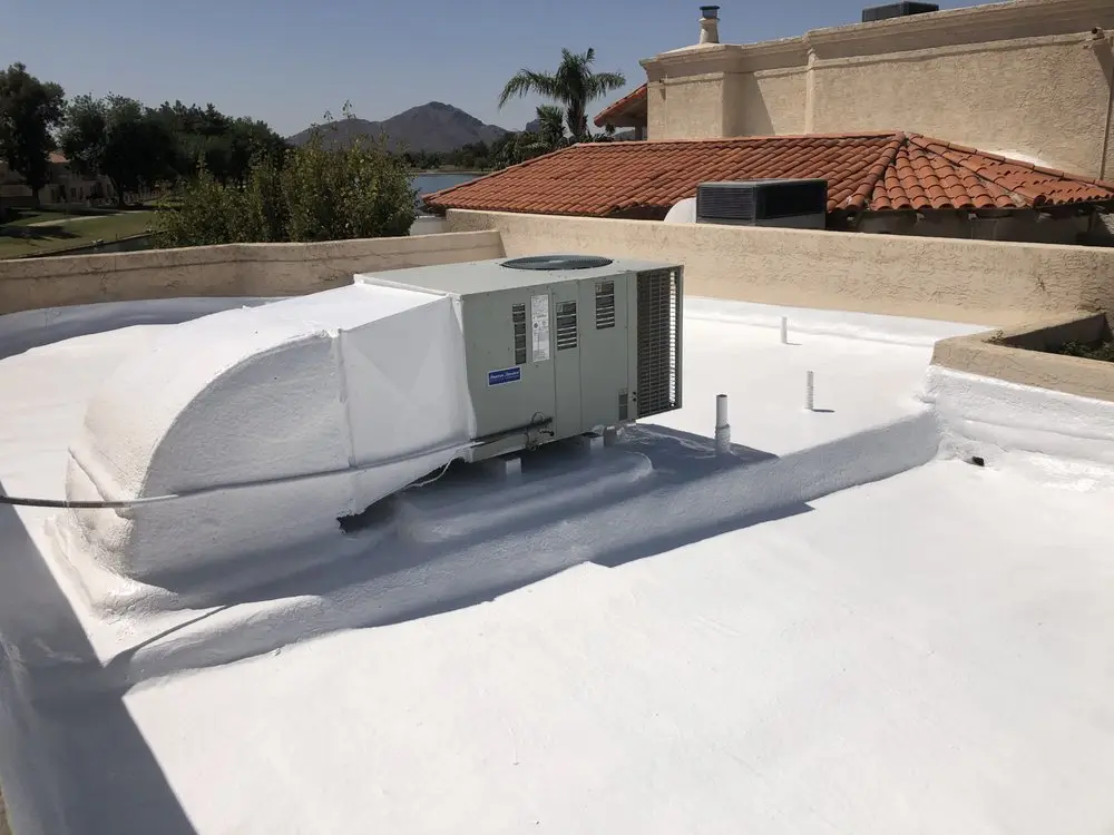 Spray foam flat roof with a white reflective coating around a rooftop AC unit in Scottsdale