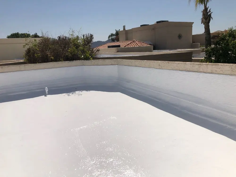 Freshly coated spray foam flat roof with sealed parapet walls in an upscale Scottsdale neighborhood, by Leal Roofing