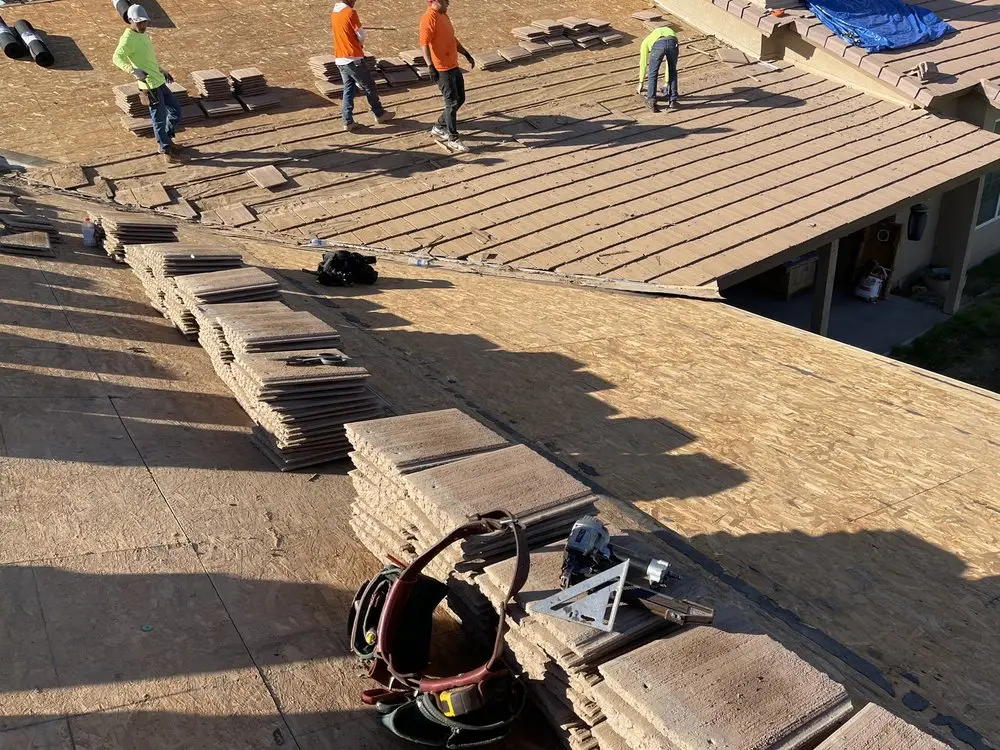 New OSB decking with concrete tiles staged for re-laying during a north Valley tile re-roof, by Leal Roofing