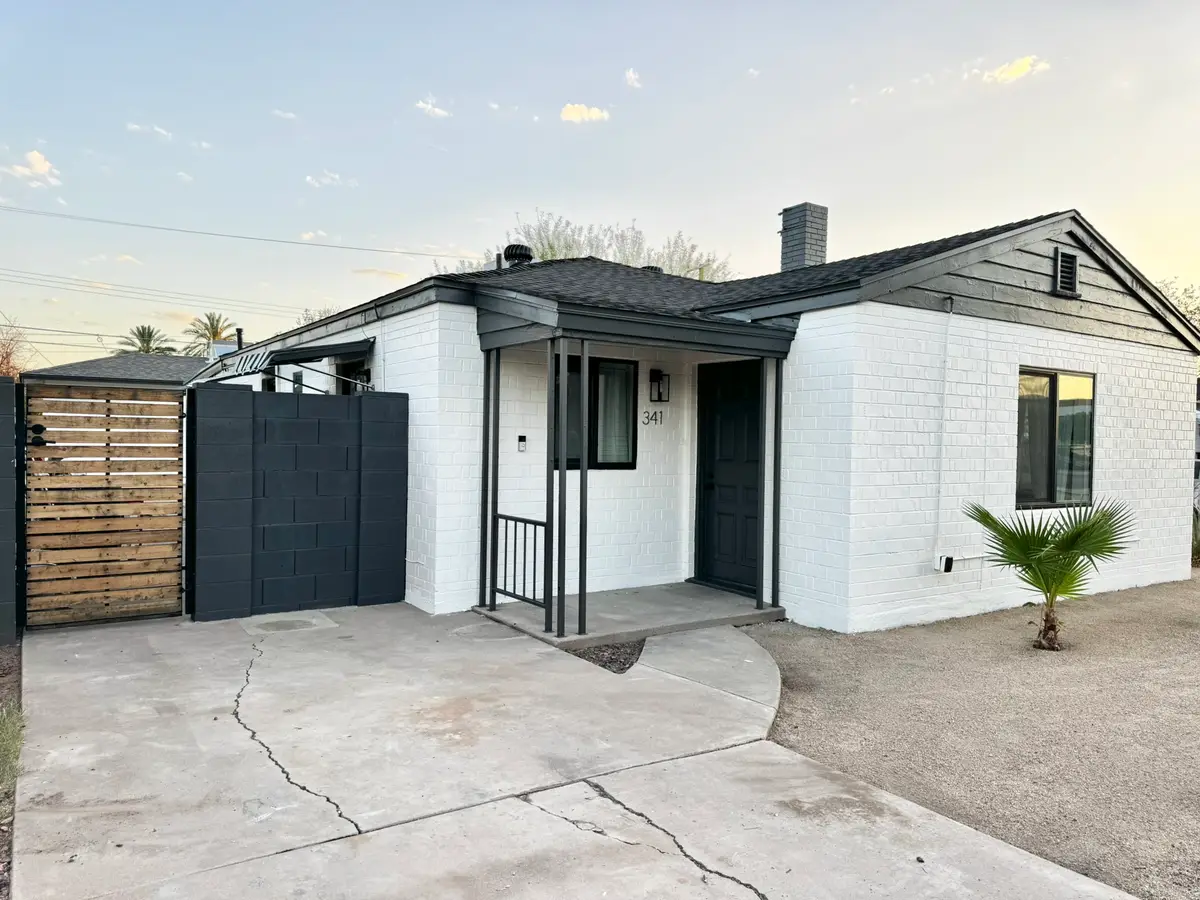 Finished charcoal architectural shingle roof and freshly painted fascia on a white brick home in central Phoenix