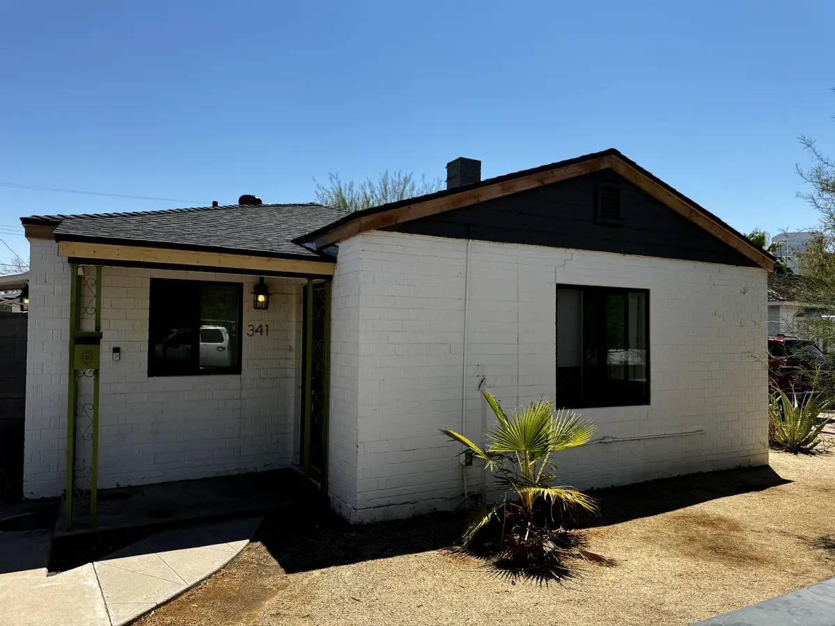 New charcoal shingles and fresh raw-wood fascia installed before paint on a central Phoenix home, by Leal Roofing